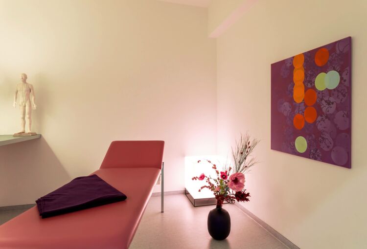 Der Blick in den Behandlungsraum für Akupunktur zeigt ein warmes helles Ambiente.